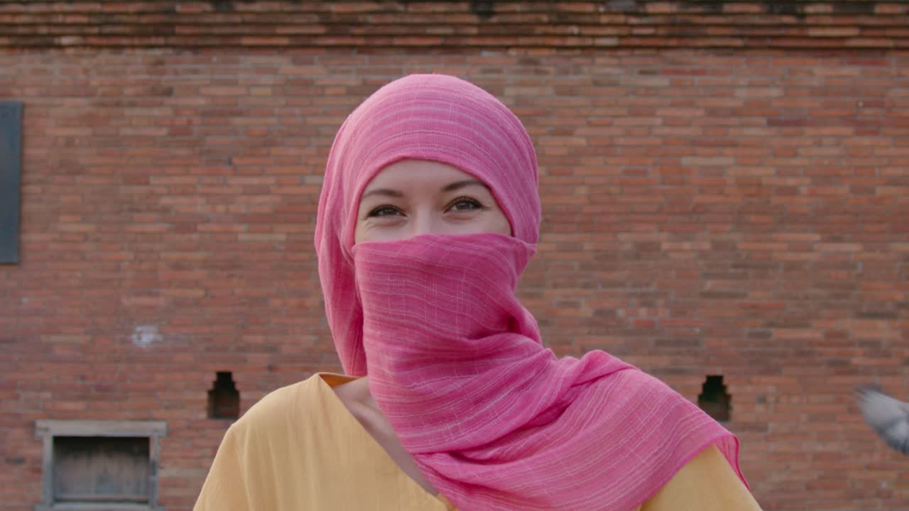 mujer con un hijab rosa