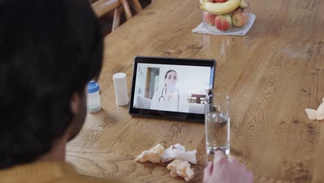 Caucasian-man-making-video-call-using-tablet-with-female-doctor-on-screen,-slow-motion