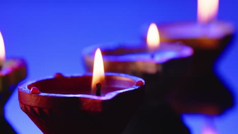 cerrar las velas encendidas en fila celebrando diwali sobre un fondo azul