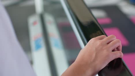 video de 4k en la mano mientras se agarra la computadora de mano en una escalera mecánica en una tienda por departamentos o en el aeropuerto