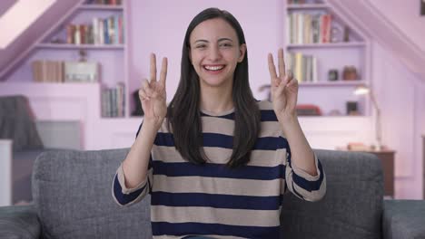 Happy-Indian-girl-showing-victory-sign