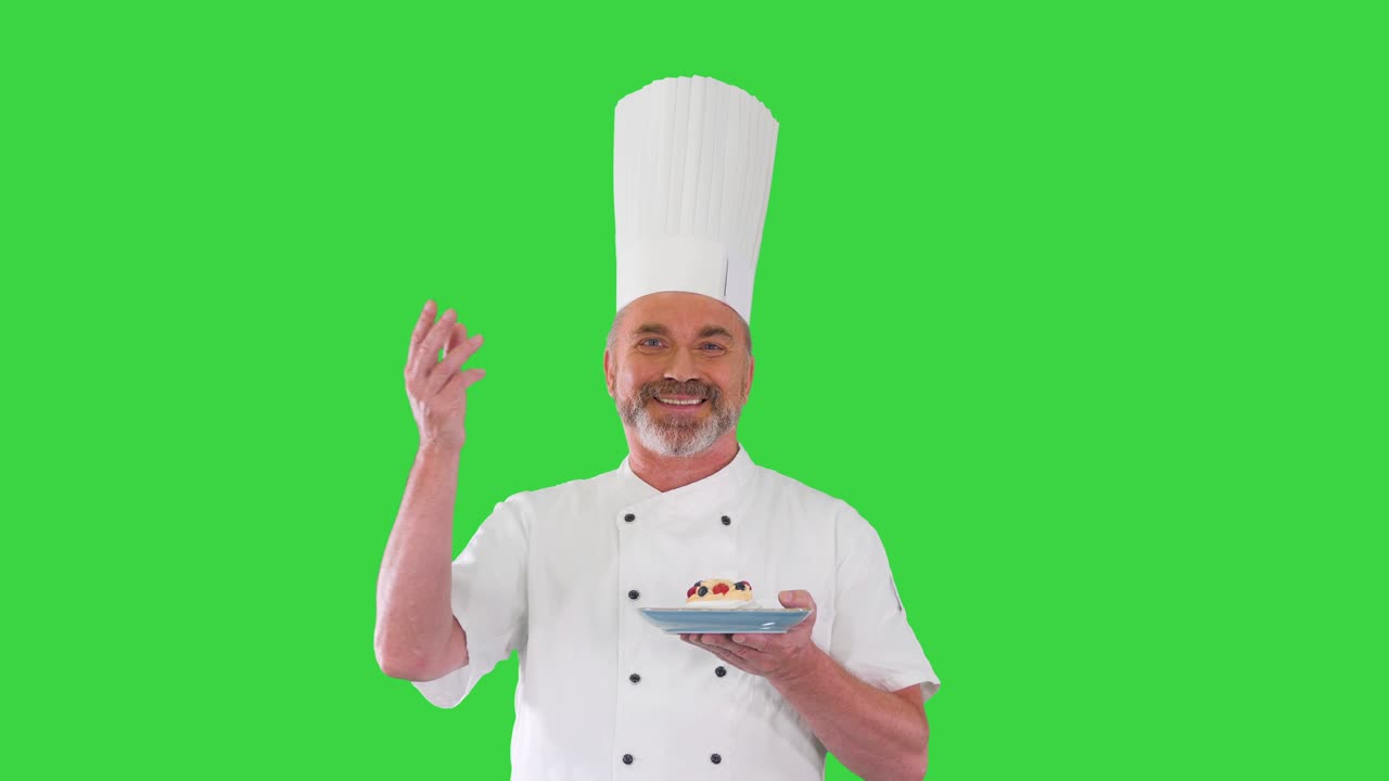 Chef, cuoco o fornaio maturo tiene un piatto con un dessert e fa un gesto di approvazione su uno schermo verde, Chroma Key