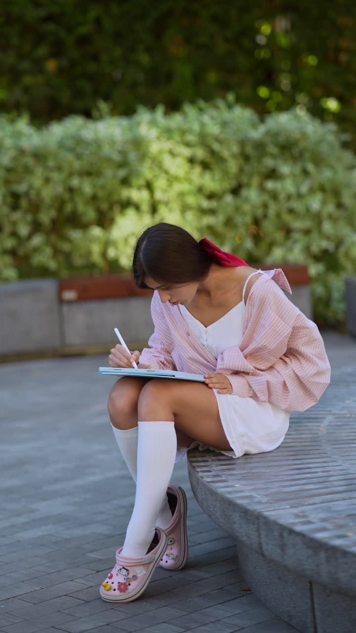 Donna che disegna su un tablet al parco