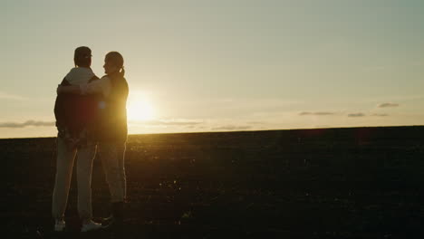 couple embracing at sunset in a field