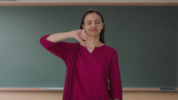 maestra india molesta mostrando los pulgares hacia abajo