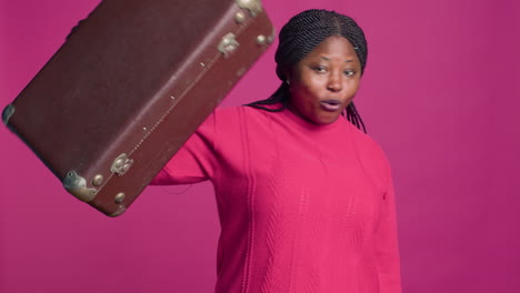 excited female holding brown suitcase