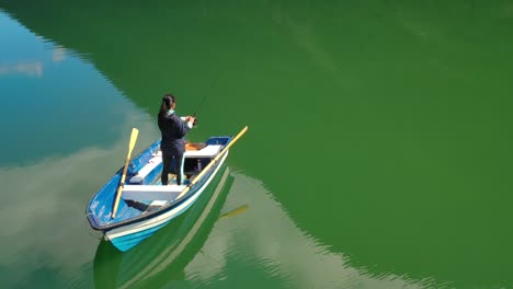 woman on the boat catches a fish on spinning in norway.