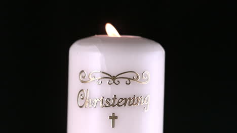 lit christening candle flickering