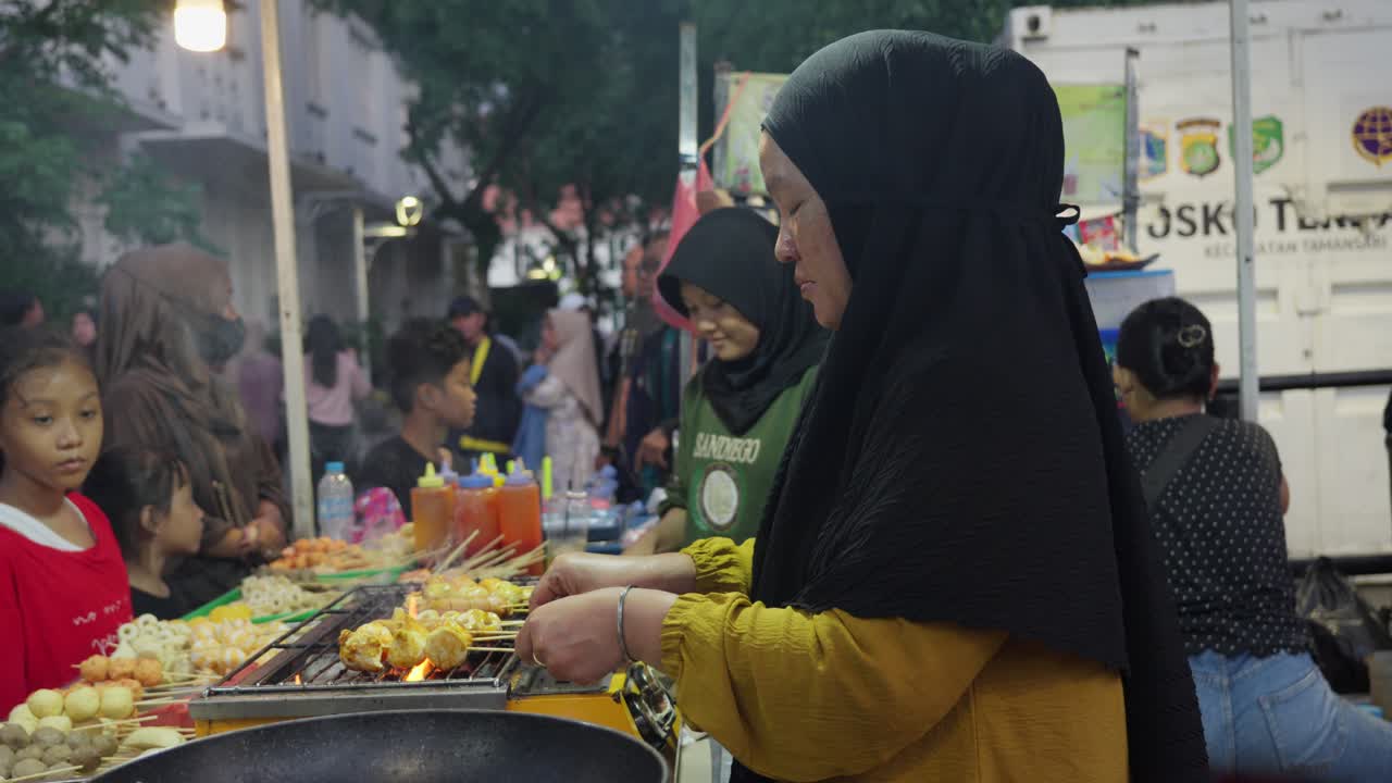 Street food vendor grilling meatballs