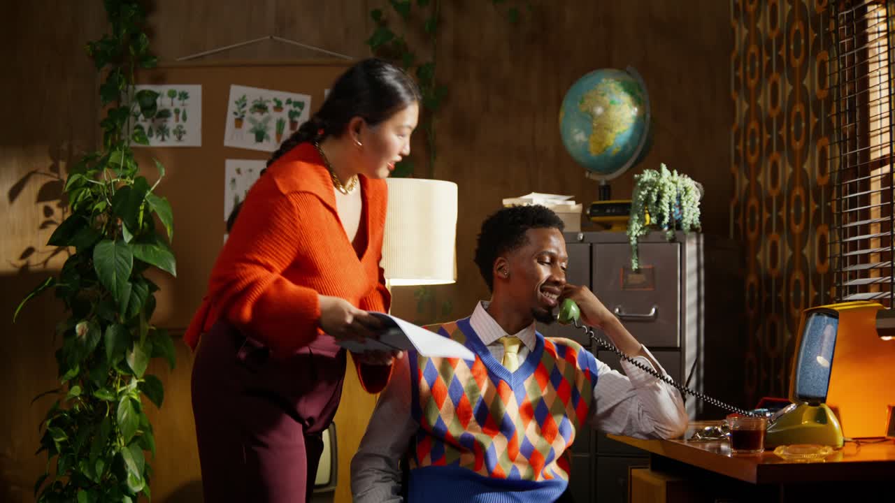 Scene fra et retrokontor med to personer