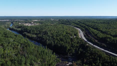 Paisaje-Boscoso-Canadiense-Con-Carretera-Sinuosa-Y-Claro-Distante