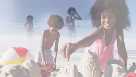 composite of happy african american brother and sister making sandcastles, and running in sea