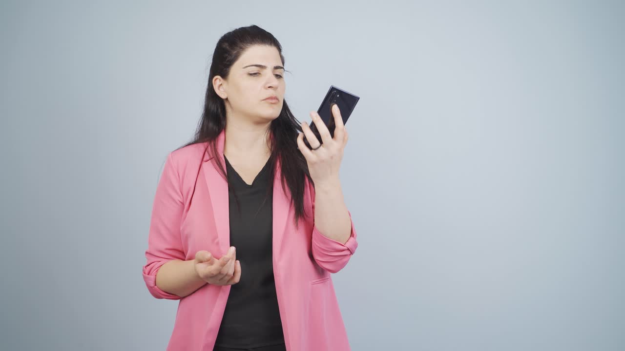 사업가 여성이 전화로 이야기하는 동안 방해받고 화를 내고 있습니다.