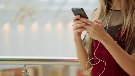 Primer-Plano-De-Niña-Con-Un-Teléfono-Móvil-Escribiendo-Un-Mensaje-De-Texto.-Mire-La-Pantalla-De-Un-Teléfono-Inteligente.-Videoconferencia-A-Través-Del-Teléfono-Móvil-En-El-Aeropuerto.