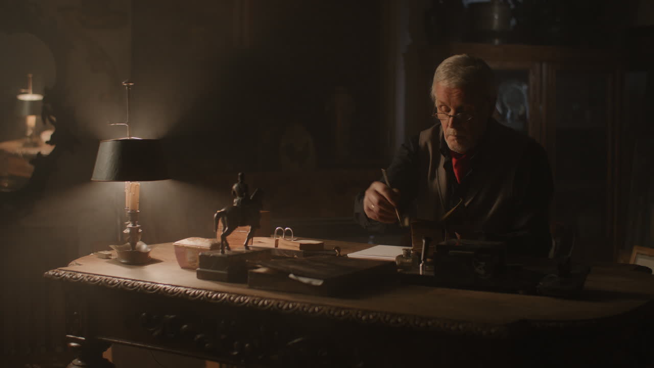 Old passionate man writes down a note in his office at night