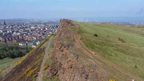 panning around the crags at arthur's seat, near holyrood parliament, with tourists walking | edinburgh, scotland | 4k at 30 fps