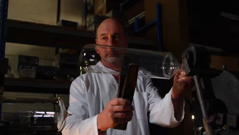 mature male worker examining chemglass in glass factory 4k