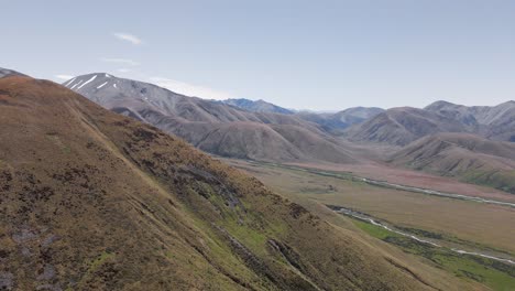 valley with two small rivers flowing in between the foothills of new zealand's southern alps on a sunny spring day