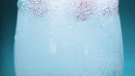 Raspberry-and-Blackcurrant-Fruits-Splashing-into-a-Glass-of-Sparkling-Water,-Studio-Close-Up-Shot