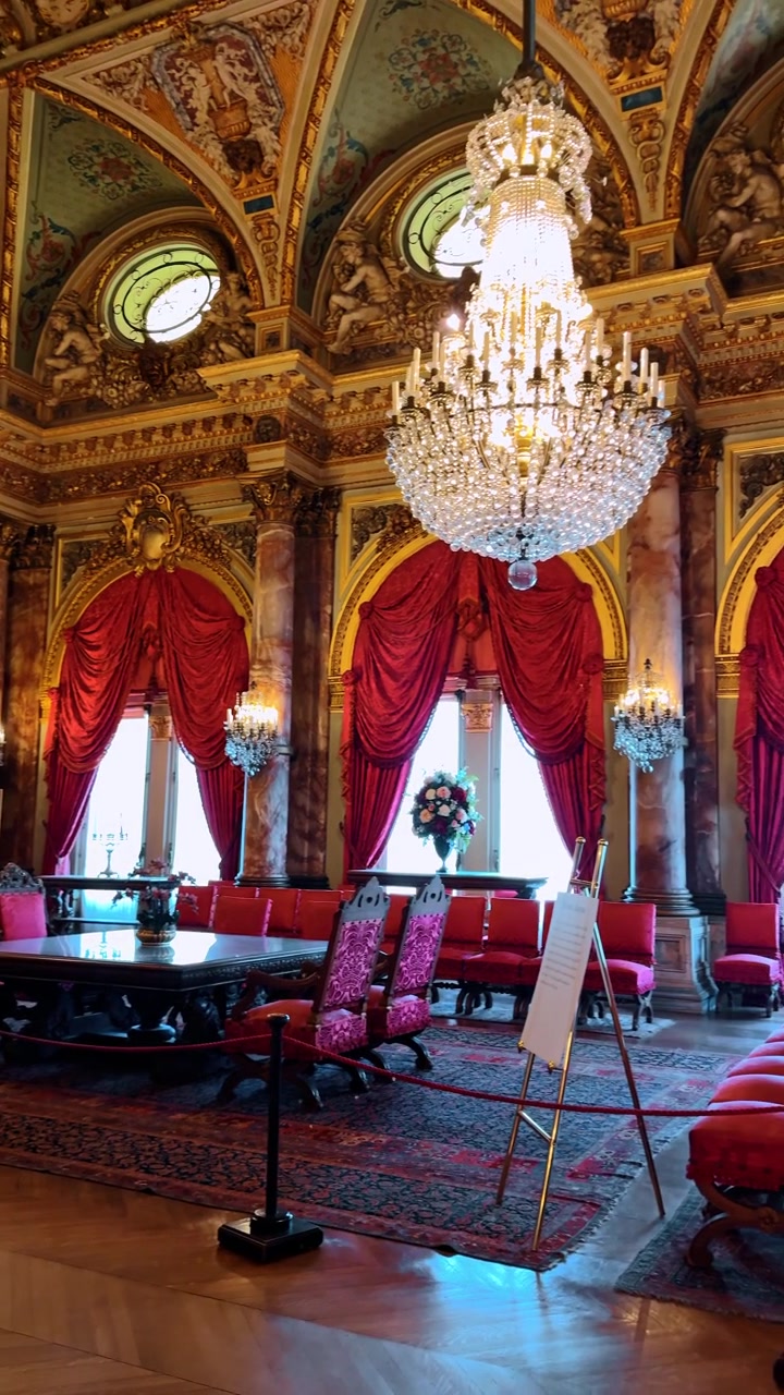 Boston, USA, 5 maggio 2025: Interno di una grande sala con colonne di marmo e drappeggi rossi. Ampia inquadratura interna che mostra pilastri di marmo, tende di velluto rosso, un lampadario di cristallo e sedute formali.