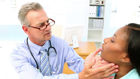 médico chequeando las glándulas del cuello de su paciente