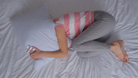 woman in bed with pills
