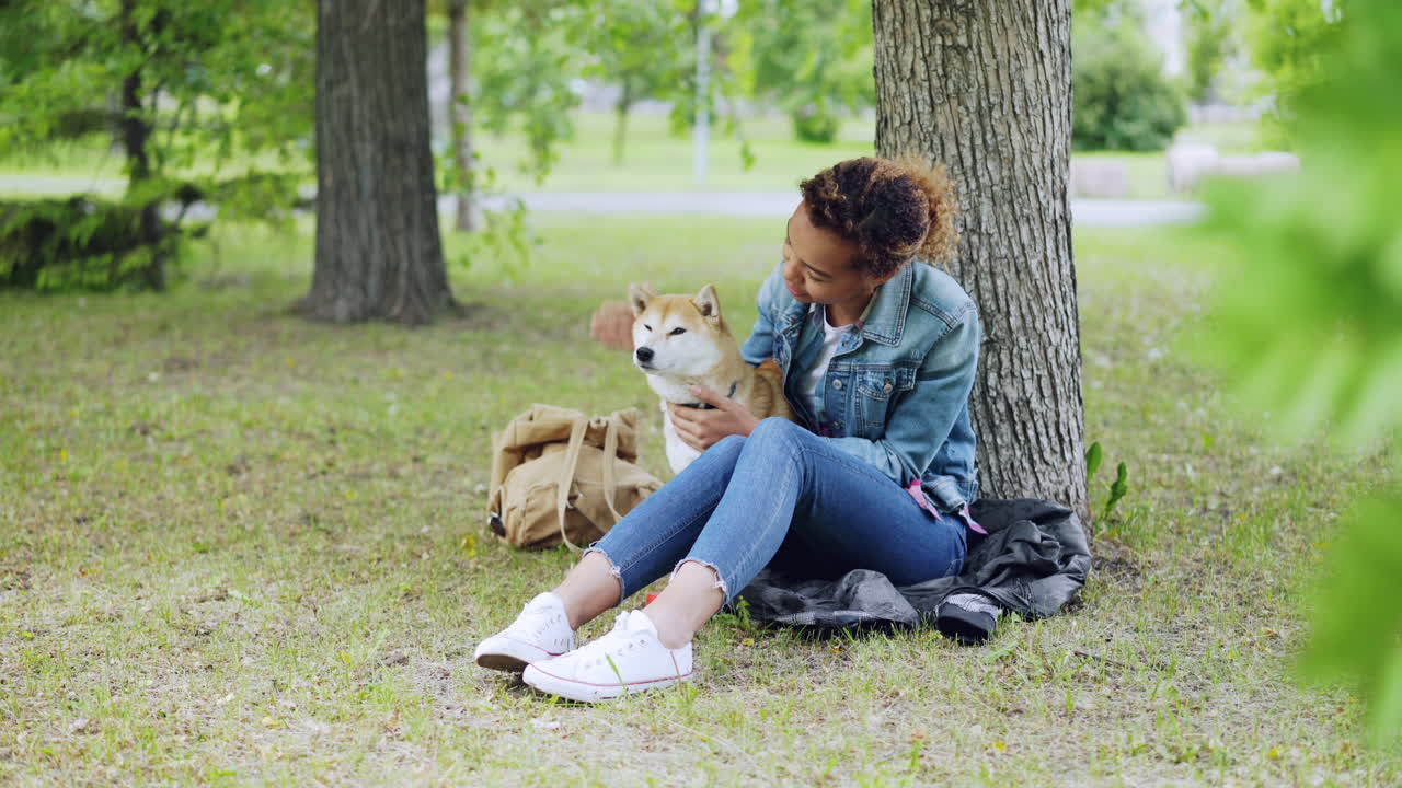 Kvinde og hund slapper af i en park