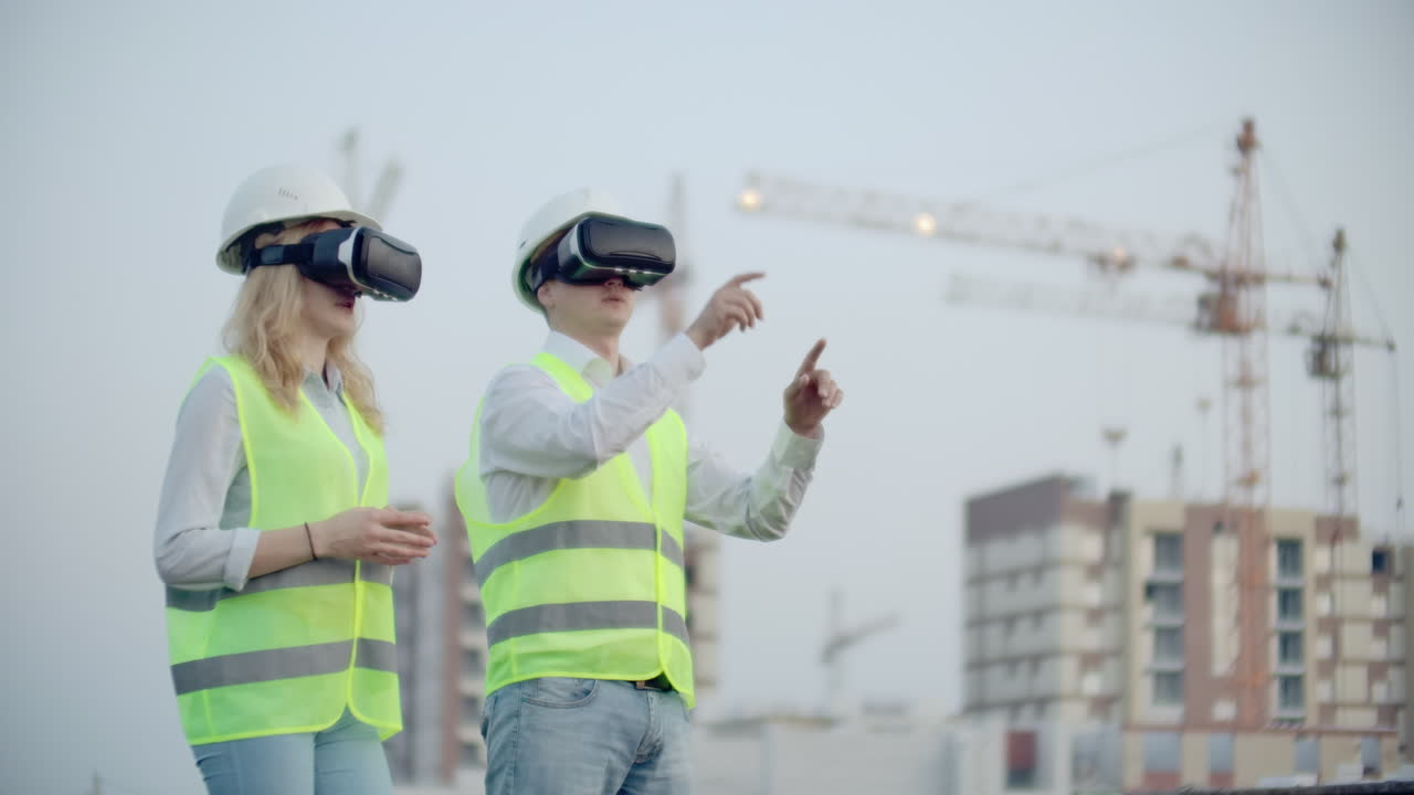 dos personas en gafas de realidad virtual en el fondo de edificios en construcción con grúas imitan el trabajo de la interfaz para el control y la gestión de la construcción.