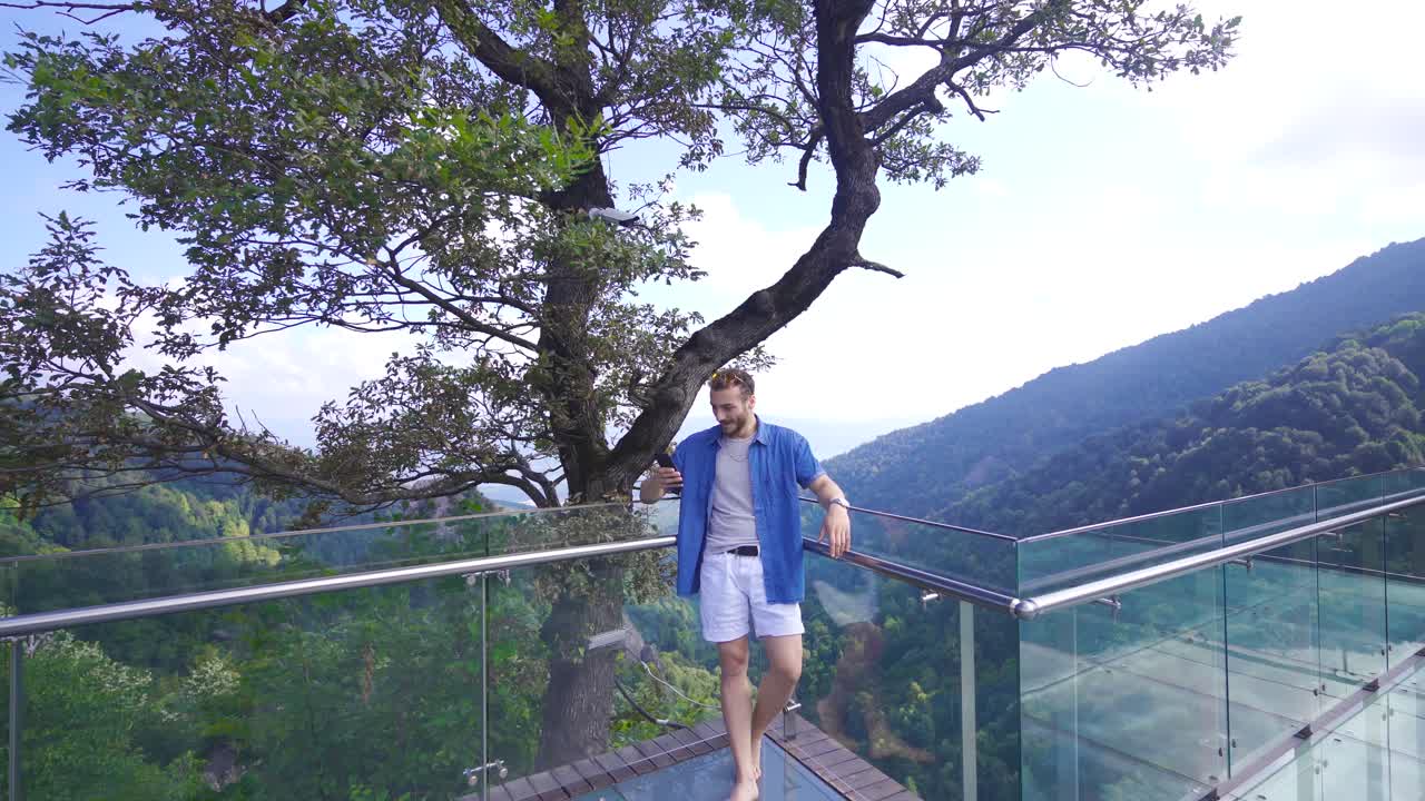 hombre enviando mensajes de texto por teléfono en el cañón en la naturaleza.
