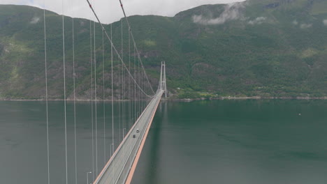 descending along side of hardanger bridge crossing large fjord in norway