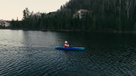 tourist oaring while kayaking in lake - drone shot