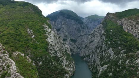 panoramic aerial view of komani lake, northern albania, with steep rocky gorge and gray cliffs.