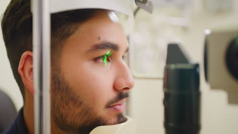 paciente masculino haciendo una prueba ocular con una optometría