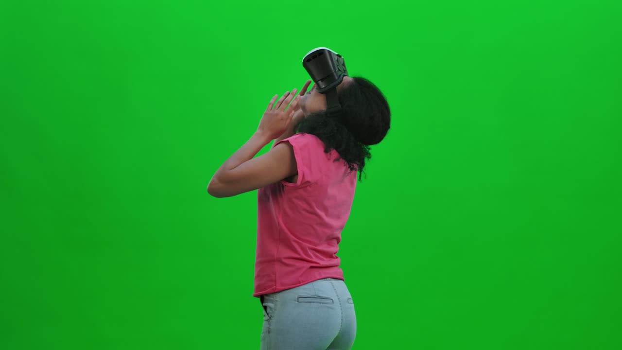 Portrait of young female African American with virtual reality headset or 3d glasses . Black woman with curly hair poses on green screen in the studio. Close up. Slow motion ready 59.97fps