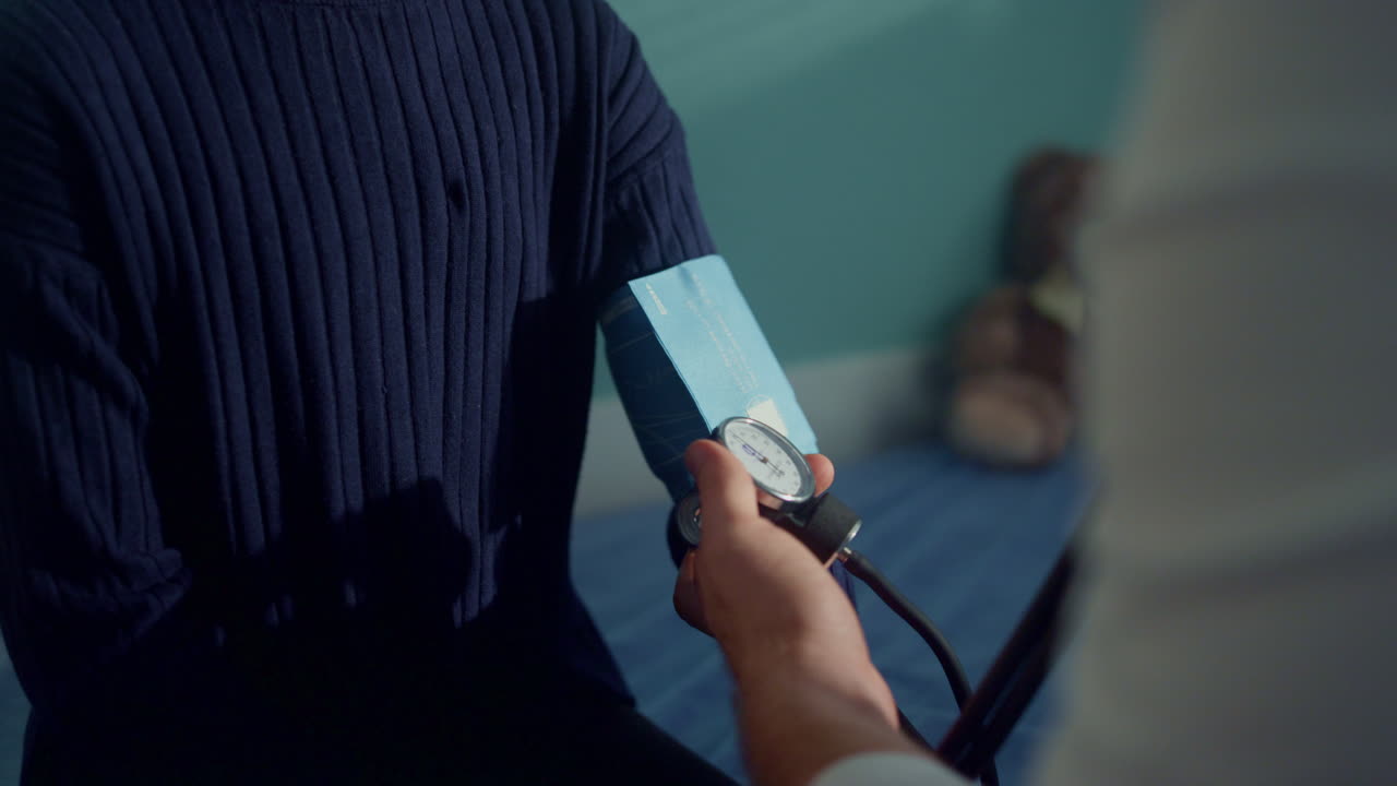 아프리카 소녀의 팔에서 톤미터를 사용하여 혈압을 확인하는 의사.