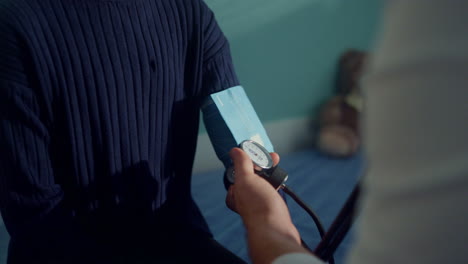 doctor checking arterial pressure using tonometer on african girl arm close up.