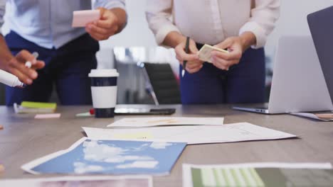 low section of businesspeople making memo notes in modern office in slow motion