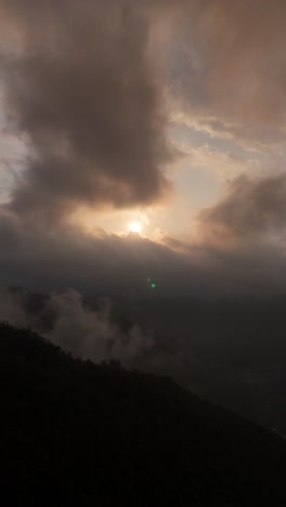 Vista-Aérea,-Vertical,-Increíble-Puesta-De-Sol-Con-Nubes-Y-Montañas