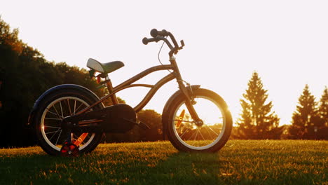 Children\'s-Bicycle-On-Green-Grass-At-Sunset-Concept---Nostalgia-Childhood-Dreams