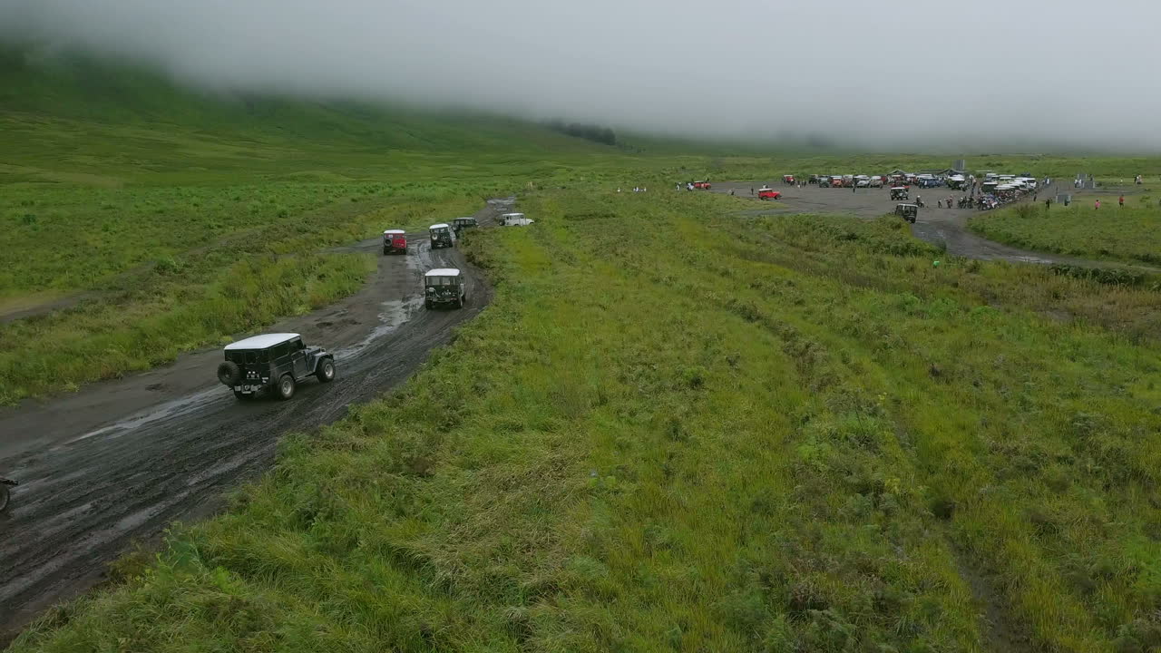 인도네시아 동부 자바의 브로모 산을 여행하는 많은 육상 순양함 지프