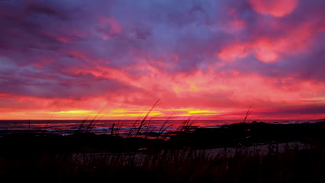 clouds on fire during golden sunset over ocean; static from shoreline