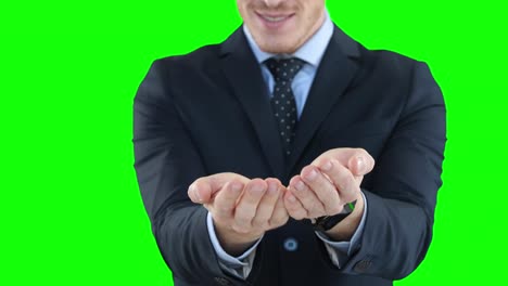 mid section of a caucasian man raising hands on green background