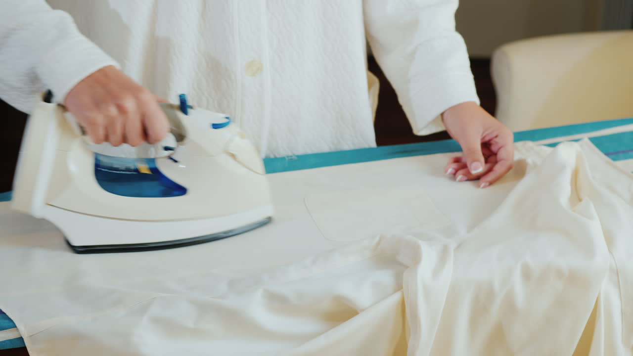 흰색 우아한 셔츠에 철 다림질 여성 손