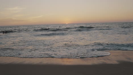 Waves-crashing-on-the-shore-during-sunset-in-slow-motion