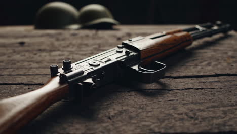 antique rifle on wooden table with military helmets
