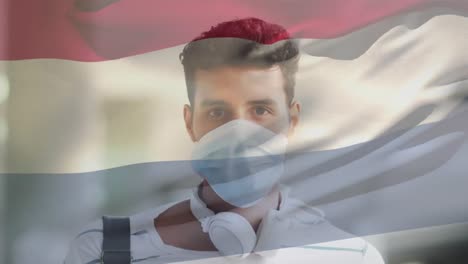 Animation-Der-Flagge-Der-Niederlande,-Die-über-Einem-Lateinamerikanischen-Mann-Mit-Gesichtsmaske-In-Der-Stadtstraße-Weht