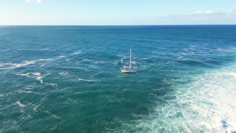 A-sailing-boat-anchored-next-to-Cook-Island-adjacent-to-Fingal-Head-in-New-South-Wales,-Australia-in-Summer