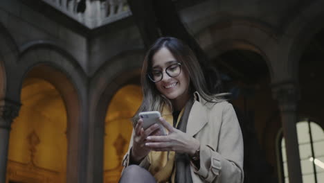 young woman typing on cellphone outside