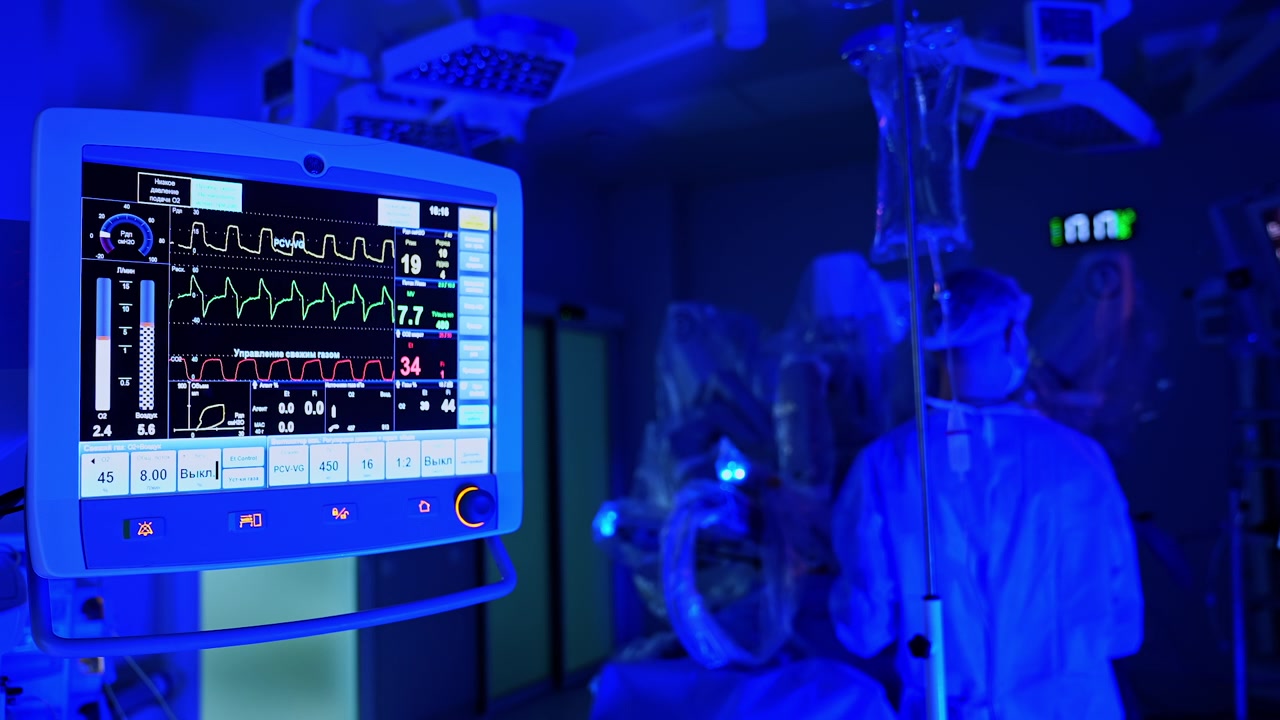 Kiev, Ucraina, 5 maggio 2026: Monitor del ventilatore per anestesia che mostra i parametri vitali del paziente durante un intervento chirurgico robotico. Schermo con forme d'onda, letture di CO2 e pressione in luce ambientale blu