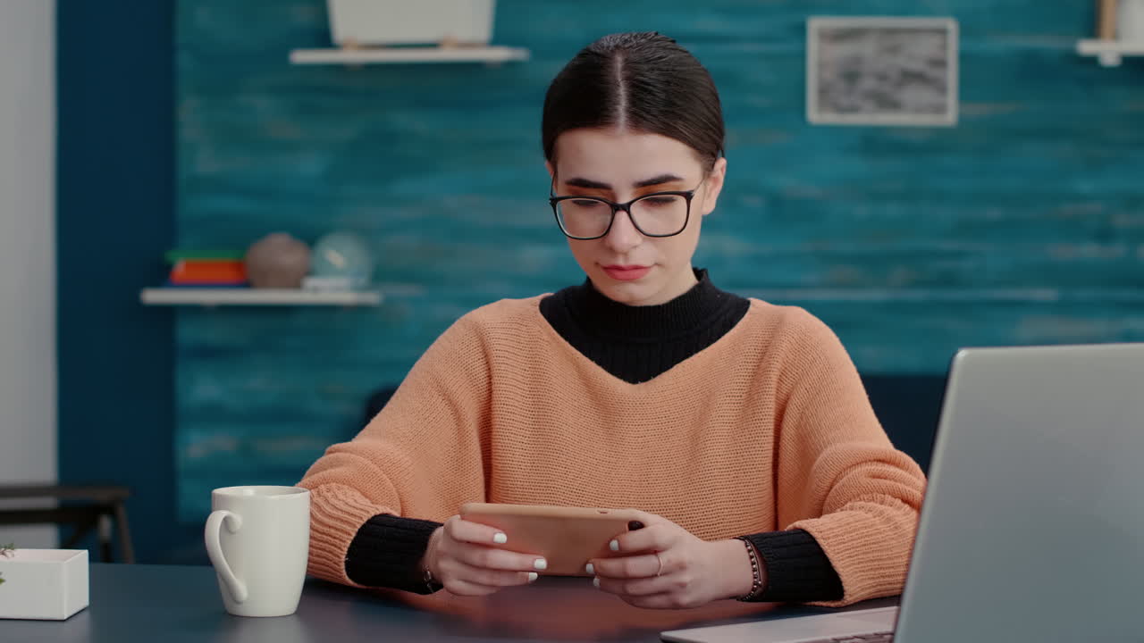 Young student playing online video games on smartphone